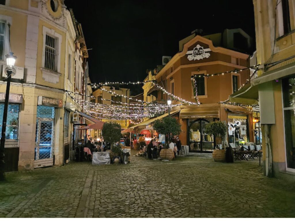 kapana district in plovdiv at night, fairy lights hanging from restaurants, cobbled streets