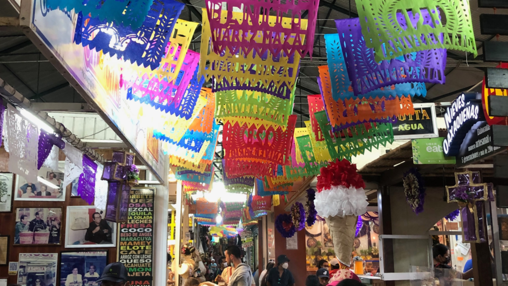 bright coloured flags hanging from inside Mercado Benito Juárez