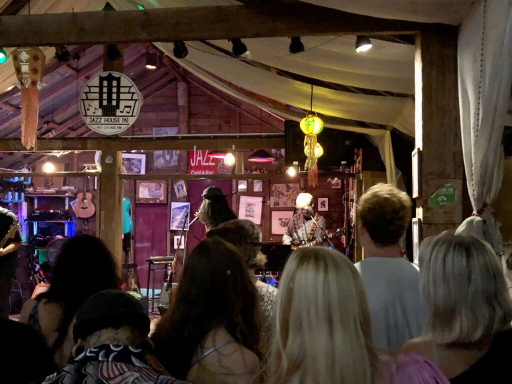 a crowd of people watching live music on a stage at Jazz House in Pai, Thailand