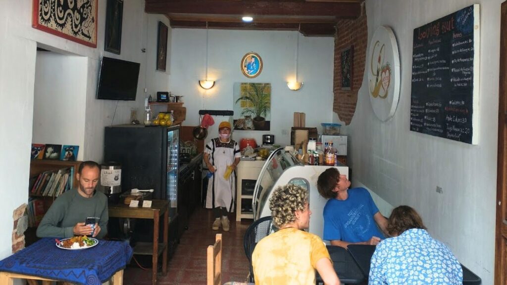 inside loving hut in san cristobal de las casas, people eating and looking at the menu