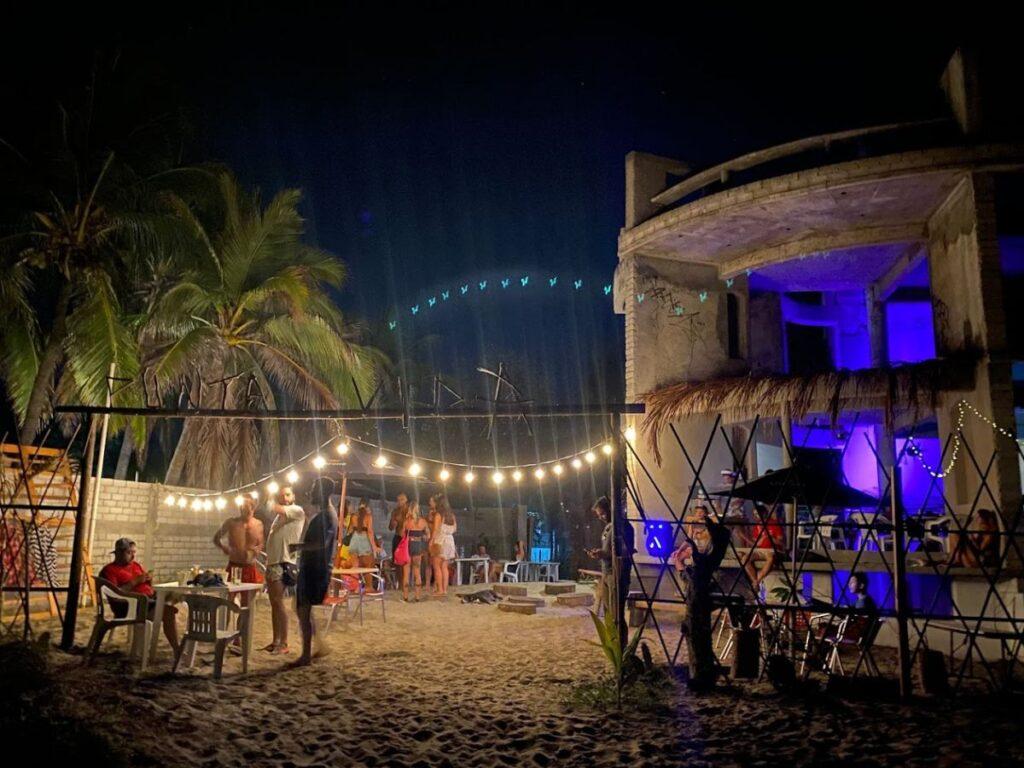 beach bar in puerto escondido, people gathered having drinks on the sand