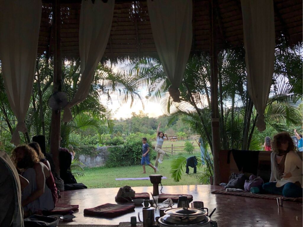 eating food at shekina garden on a sunday, children playing on the grass in the foreground