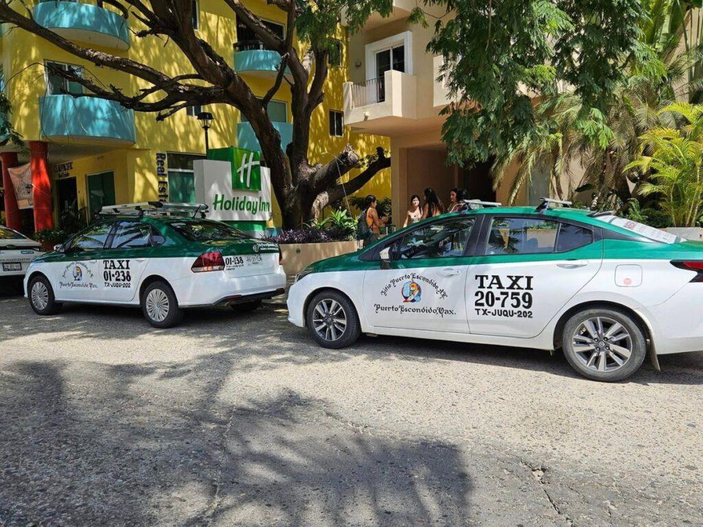 green and white taxis parked in puerto escondido