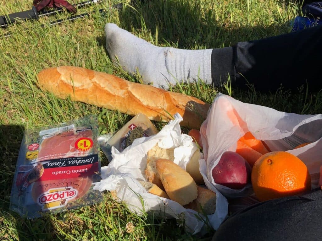 baguette, cheese, oranges on grass of Camino de Frances, best budget tip