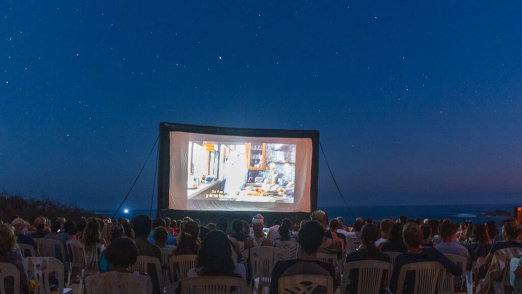 lots of people watching outdoor cinema at Villa de Sol, sand of playa bacocho beach, puerto escondido