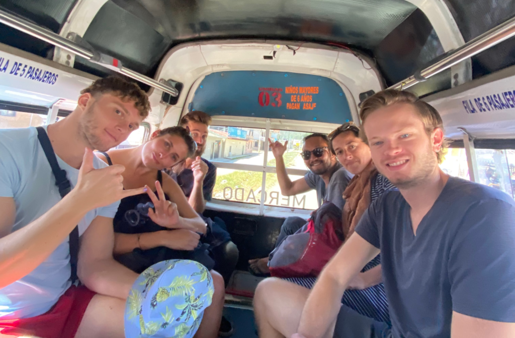 group of people in back of colectivo in san cristobal smiling