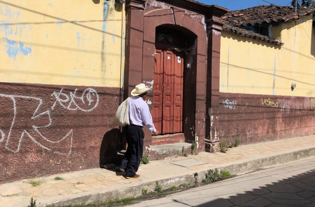 cowboy walking down on narrow pavement in san cristobal