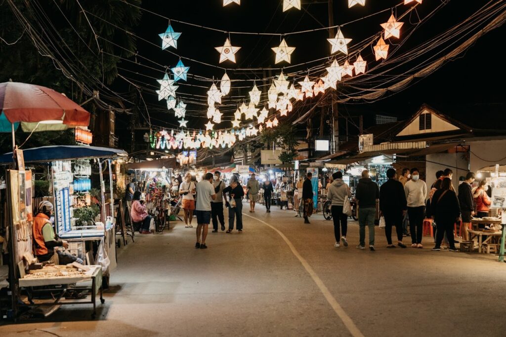 thai lanterns hanging in Pai, Walking Street at night, food stalls and people either side