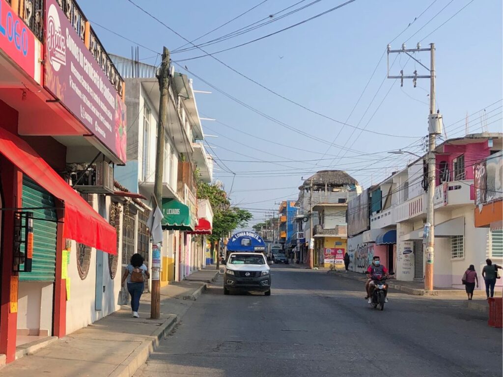 colectivo (local mexican bus) driving down the street in centro puerto escondido mexico