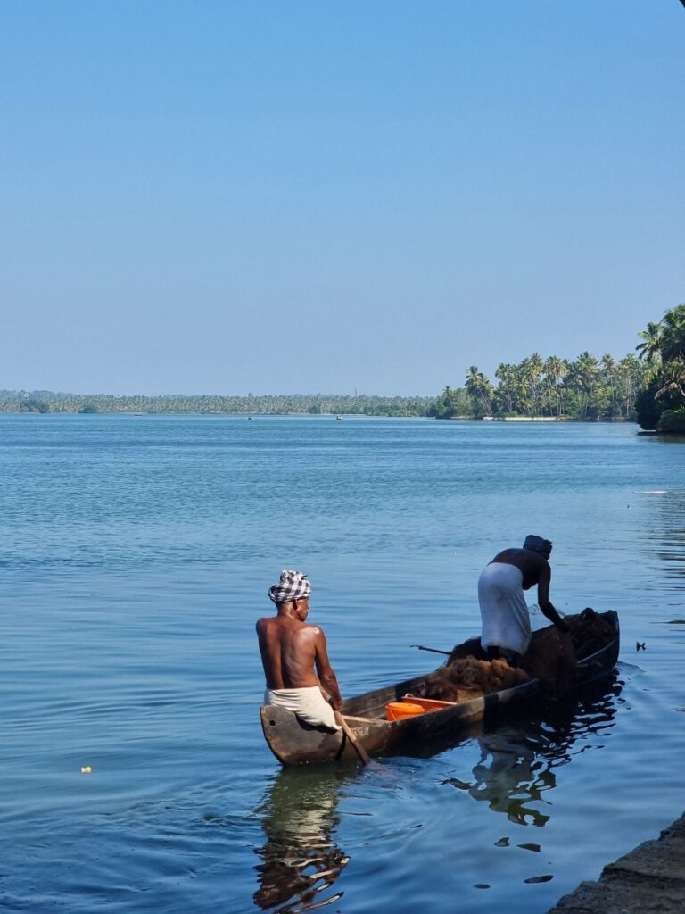 two fisherman fishing in a canoe boat on the backwaters, munroe islands
