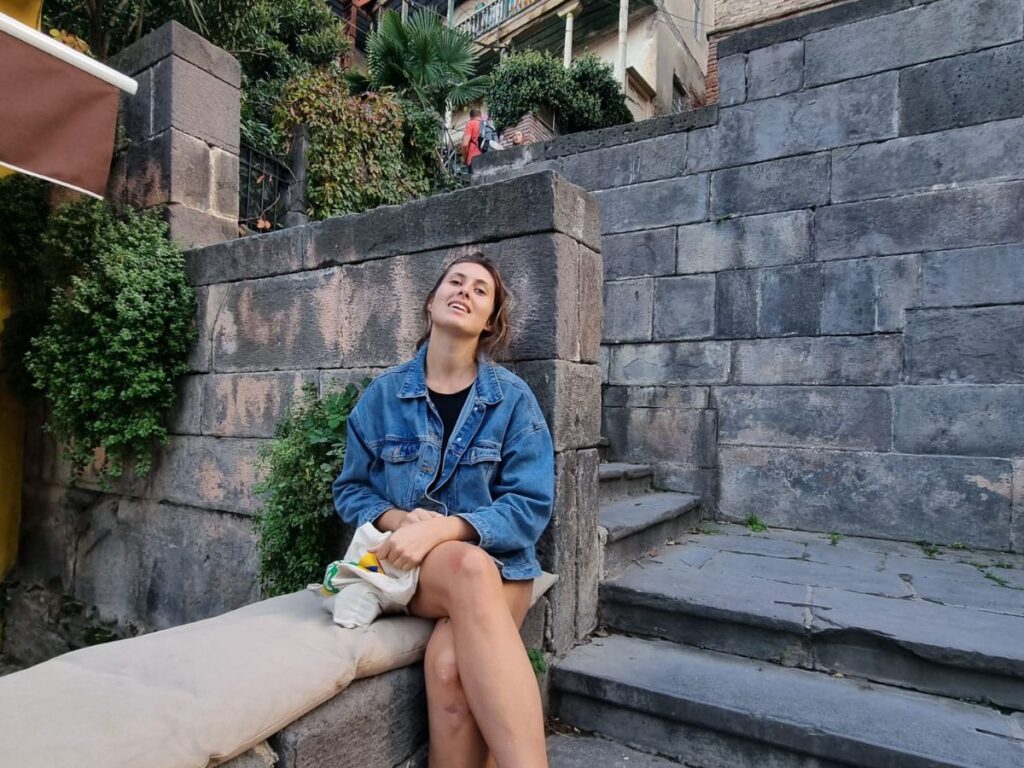 julie (writer of real talk travel) sitting on steps of Betlemi stairs on way to Mother of Georgia Statue, Tbilisi