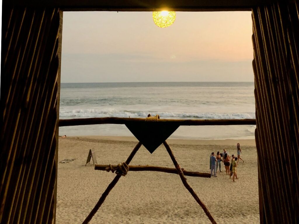 window view of travellers at sunset on Playa Zipolite, Oaxaca - great day trip from Puerto Escondido