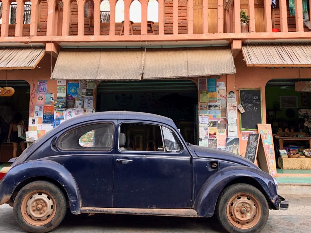 vintage card parked outside juice shop on main street of mazunte, oaxaca