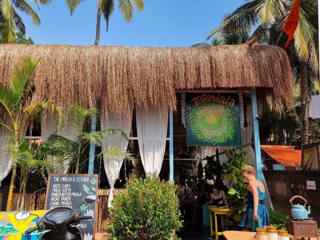 Girl standing outside vegetarian cafe called Mandala Cafe, Agonda.