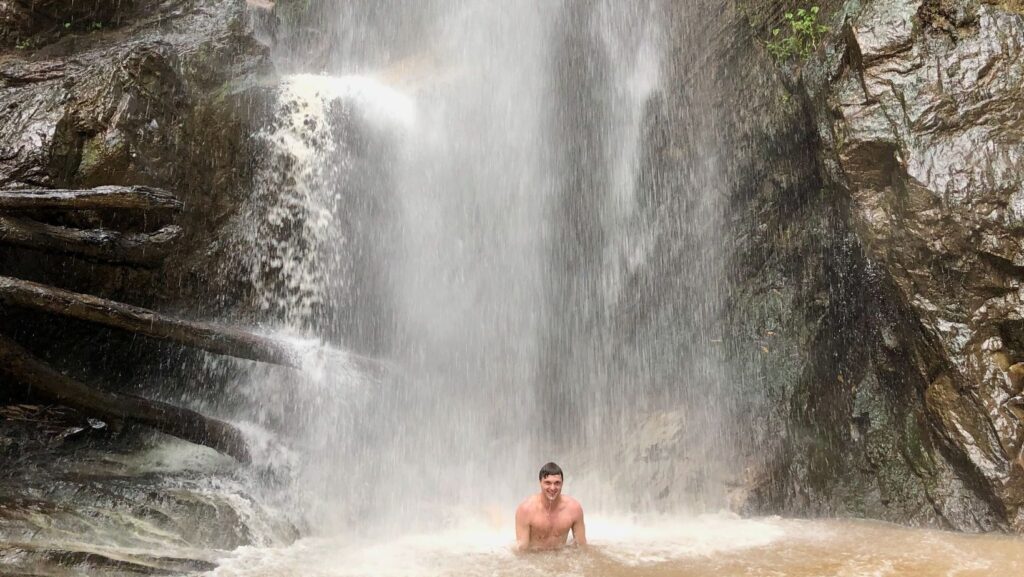 Man underneath Mok Fa Waterfall en route to Pai