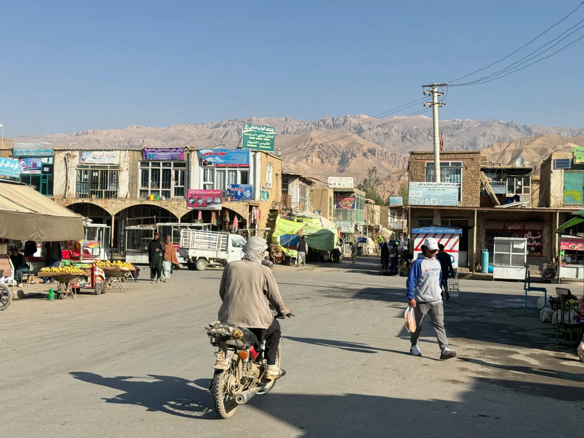Man cycles on main highstreet of Bamyan