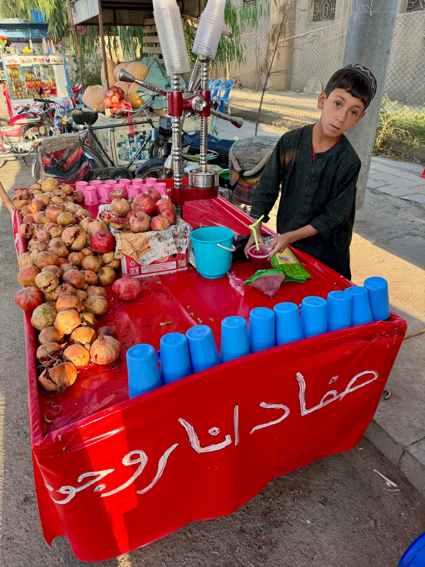 Boy selling pomegranate juice to tourist in Herat, Afghanistan