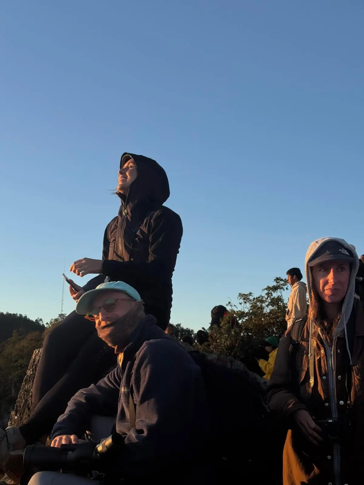 Two people smiling on top of Don Lauro mountain at sunrise.