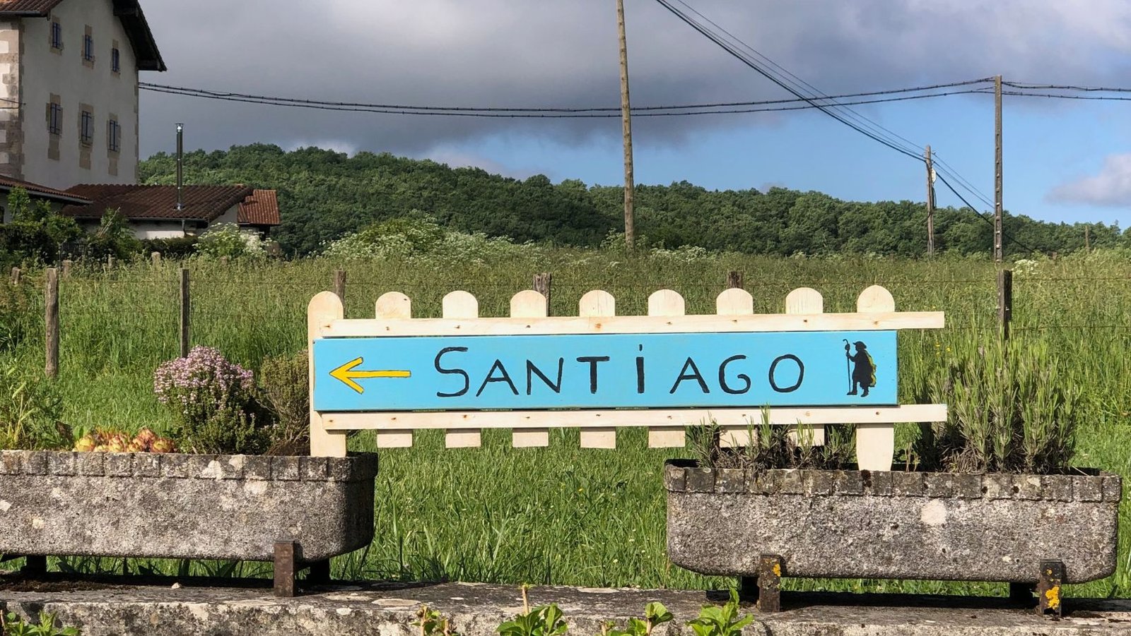 A sign with a pilgrim pointing to Santiago on the Camino Frances.