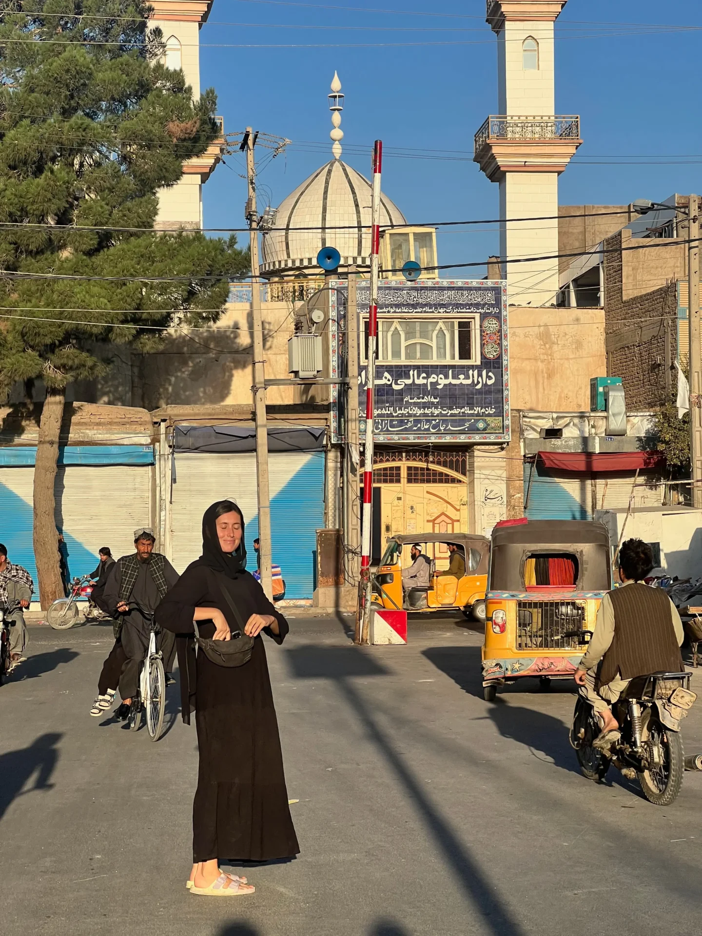 Female solo traveller standing on street smiling in Herat, Afghanistan
