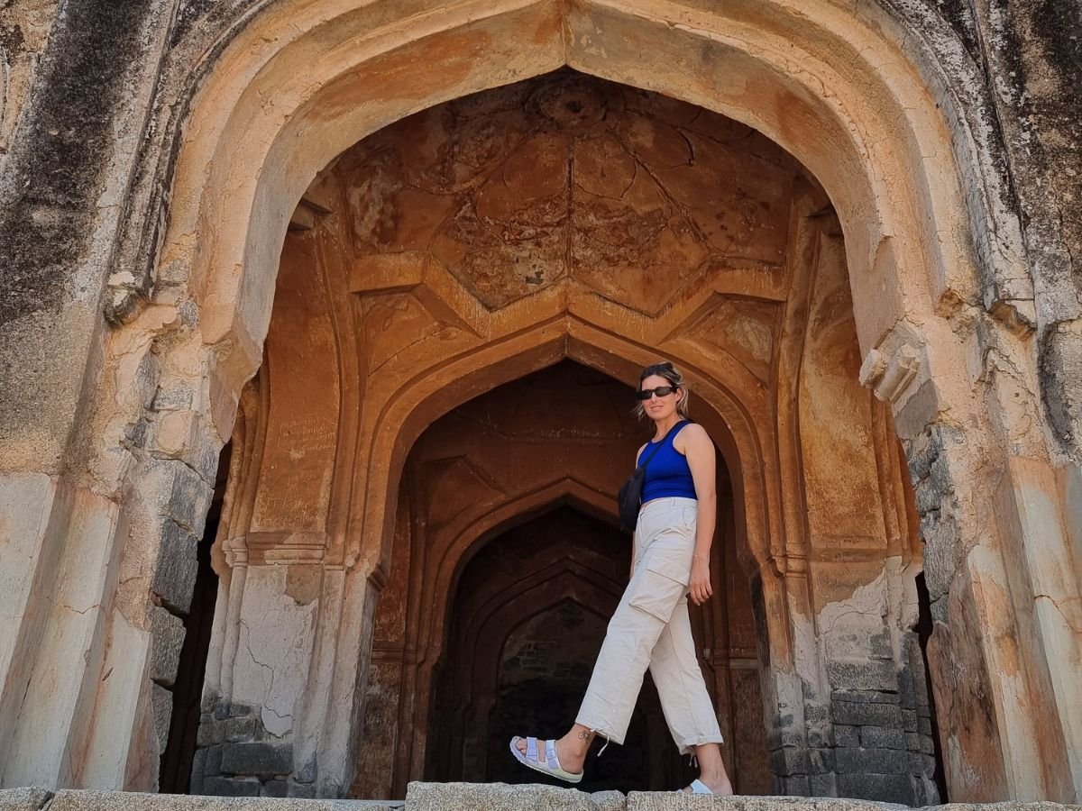 Female solo traveller smiling in front of Jamia Mosque, Hampi
