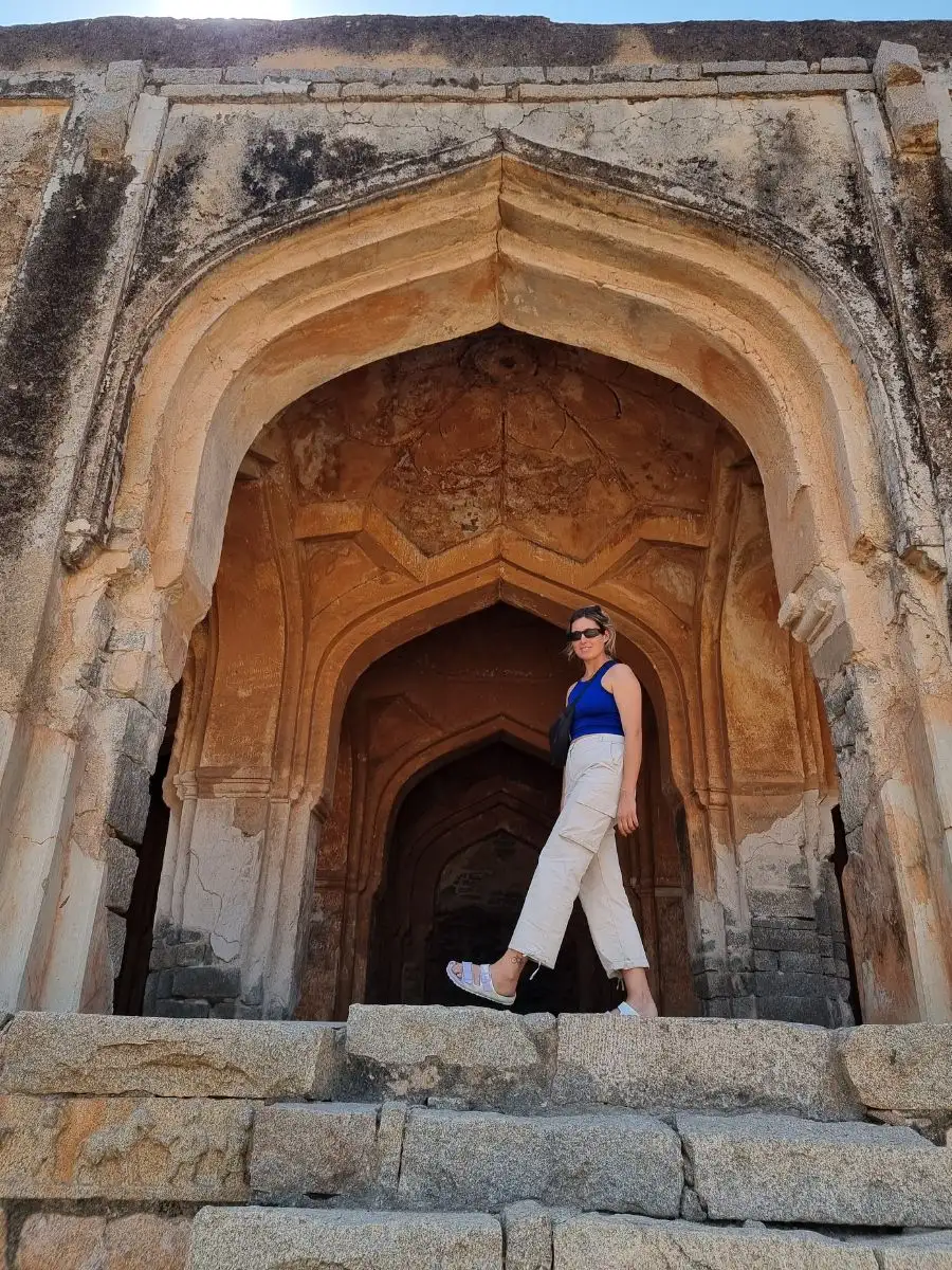 Female traveller smiling in front of temple in Hampi, India