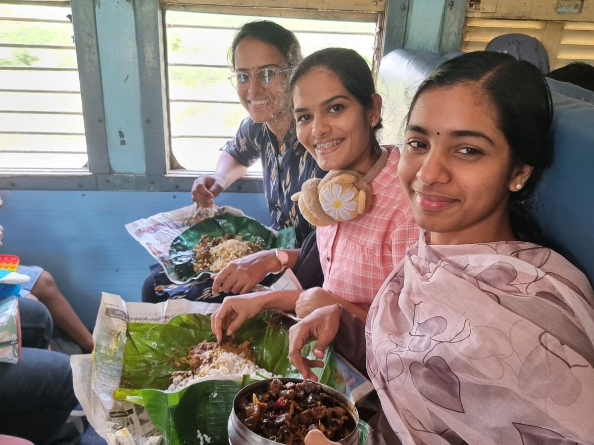 Three Keralan girls enjoying lunch on train in India.
