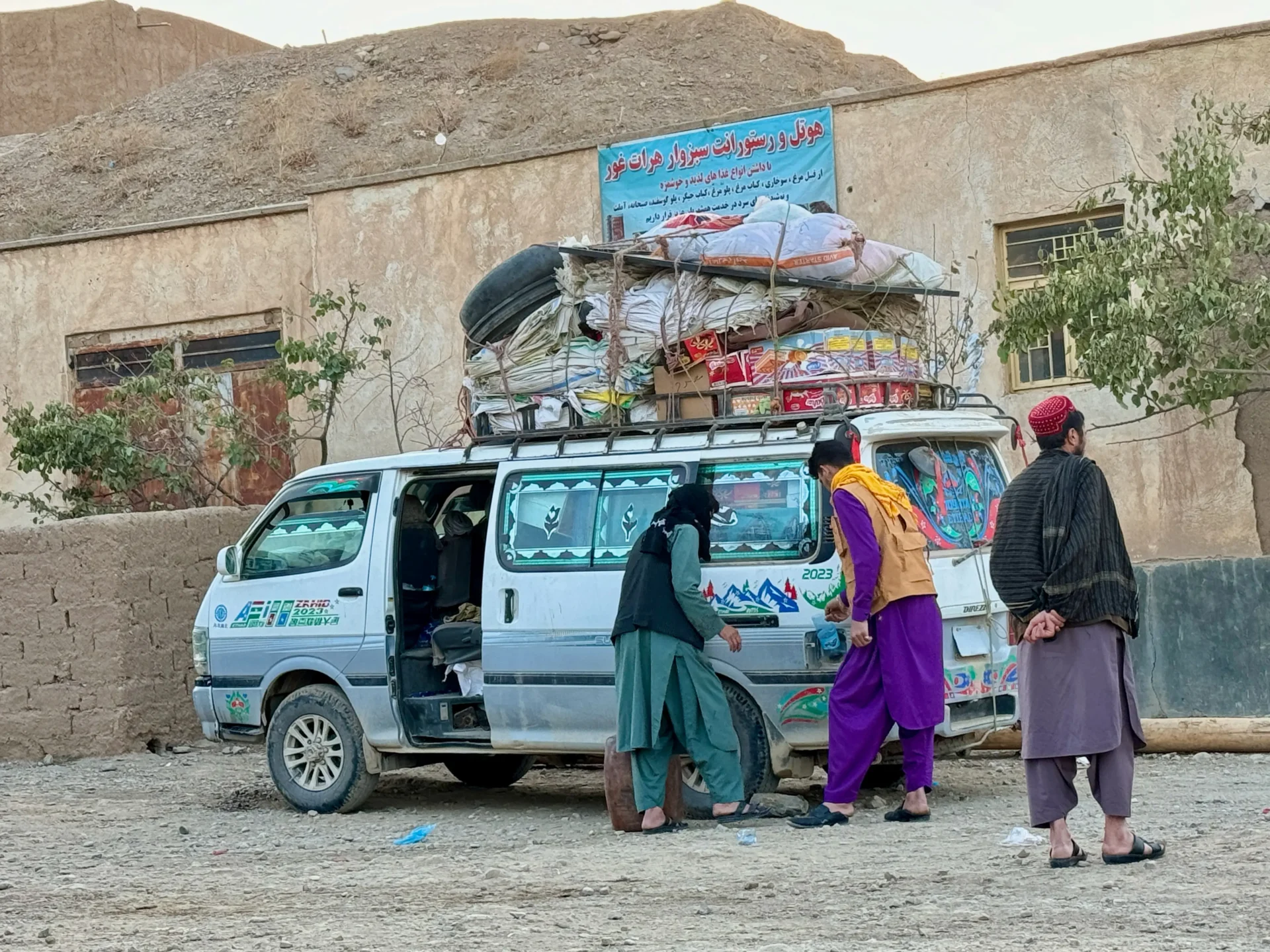 Men standing in front of minibus from Bamyan to Herat.
